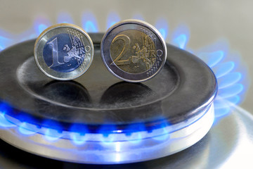 Burning natural gas and euro coins on gas hob