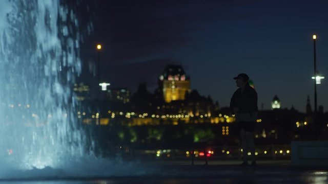 People admiring the Fontaine Du Quai Paquet, at dusk