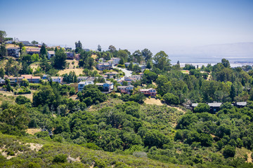 Fototapeta na wymiar Residential neighborhood on top of a hill near Pulgas Ridge OSP, Dumbarton bridge and the bay in the background, San Carlos, San Francisco bay area, California