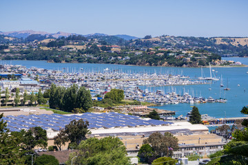 Aerial view of the bay and marina from the hills of Sausalito; solar panels installed on the rooftop of a building, San Francisco bay area, California