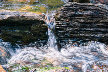 Close up of water falling through rocks on the course of a creek, California