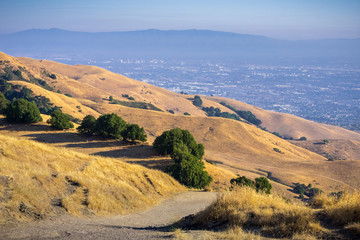 Trail through the golden hills of Mission Peak preserve; downtown San Jose in the background, south...