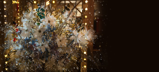 Obraz premium Bouquet of flowers on the street at night it snows. Holiday decoration of the city. Place for your text.