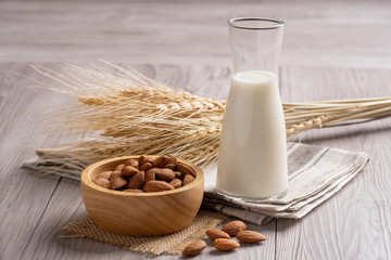 Almond milk with almond on a wooden table. 