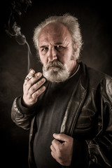 Obraz premium Grumpy senior man smoking