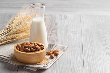 Almond milk with almond on a wooden table.