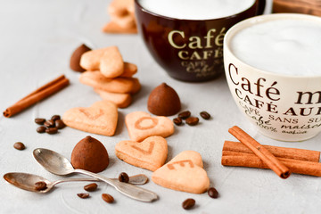 Fototapeta na wymiar romantic Breakfast: two cups of coffee and cookies in the shape of hearts, on the cookie letters LOVE. the concept of a gift for Valentine's day on February 14. selective focus