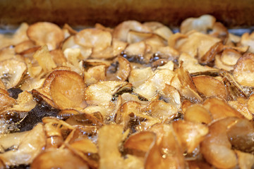 Potato chips in deep fat fryer.  Macro close up with lots of bubbling action.