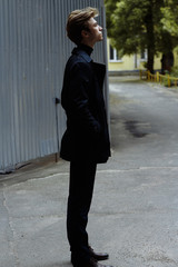 Portrait of a handsome, attractive, young man in a blue suit, coat, in the city. pensive and sad, waiting.