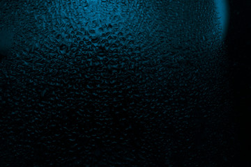 contrast drops on the glass, blue tint, dark fogged glass, texture, background 