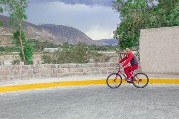 Landscape, mountains and nature. The road is laid with a stone and a man rides it on a bicycle, drives along the road.