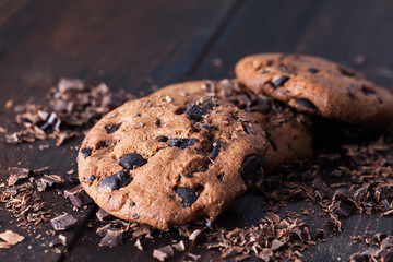 Homemade chocolate cookies on dark old wooden table. Chocolate chips cookies shot.