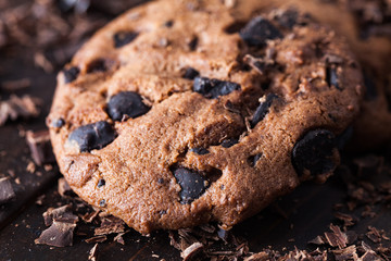 Fototapeta premium Homemade chocolate cookies on dark old wooden table. Chocolate chips cookies shot.