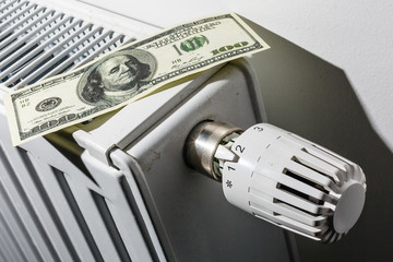 Closeup of a radiator thermostat with many dollars.