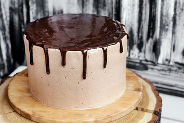Chocolate cake with mirror glaze on wooden background. Picture for recipe or confectionery catalog.
