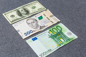 Banknotes of hryvnia, dollars, euro close-up lie on the table. Background texture