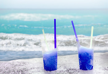 Two blue drift-ice with straw on the beach. In the background is blue sky, palms, sea nd sandy beach. This is situated in tropical resort in Asia © Jana
