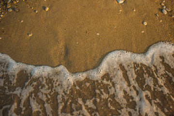 Obraz premium aerial wallpaper background concept photography of washed away human foot prints from sand shoreline surface by fuzzy waves, sea and summer vacation theme with empty copy space for your text