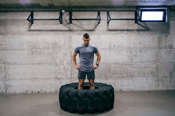 Fototapeta na wymiar Caucasian man preparing to lift tire on his cross-fit training. Hands on hips. Your limit is you.