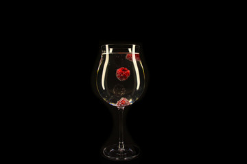 Raspberries with bubbles in a glass of carbonated drink.