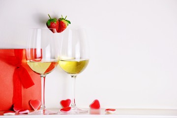 Two glasses of white wine with strawberry heart shape. Valentine's day 