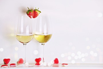 Two glasses of white wine with strawberry heart shape. Valentine's day 
