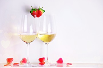 Two glasses of white wine with strawberry heart shape. Valentine's day 