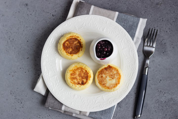 Cottage cheese pancakes or fritters with blueberry sauce and mint. Traditional Ukrainian and Russian cuisine. Syrniki. Healthy and diet breakfast.