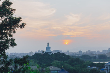 White Pagoda of Beihai Park against sunset, viewed from Jingshan Park, in Beijing, China
