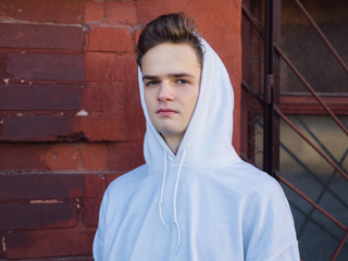 portrait of a cute serious teenager against a brick wall background