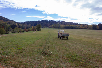 tractor and old senior farmer raking lawn