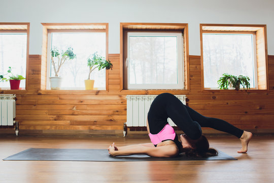 young women doing yoga asana easy plow pose. Purva Halasana. - Powered by Adobe