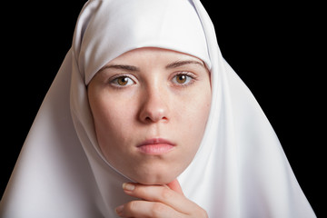 Young nun in white dress, facial closeup portrait isolated on black