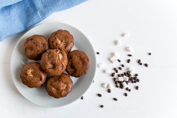 Photo of homemade muffins with dry flowers on wooden background. Homemade baking. Chocolate muffins with bananas. Chocolate banana cake