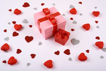 red and silver hearts on a white background around a large gift box. Valentines day.
