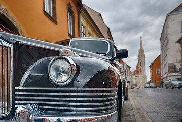 Medieval European city street with old car