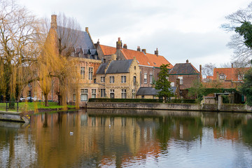 Naklejka na ściany i meble BRUGES, BELGIUM – January 3, 2019: Canals, roofs and facades of the city which was proclaimed as a historical heritage
