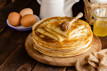 Homemade thin crepes with honey, pancakes on wooden rustic background - obrazy, fototapety, plakaty