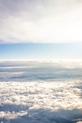 Fototapeta na wymiar Isolated sky cloudscape with fluffy clouds on horizon and bright soft sunny sunlight aerial high angle vertical view of from airplane
