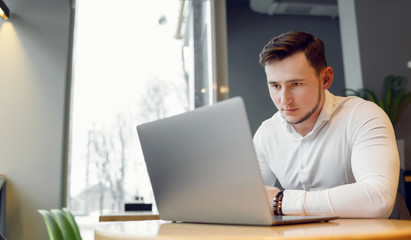 Young man using laptop in a cafe shop.