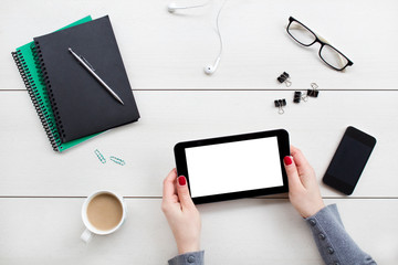  Female hands holding digital tablet. Office desktop on white background.