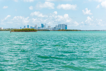 Sunny day in Bal Harbour, Miami Florida with light green turquoise ocean Biscayne Bay Intracoastal water and cityscape skyline of Sunny Isles Beach