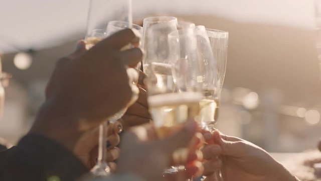 close up happy group of friends making toast drinking champagne celebrating rooftop party enjoying diverse reunion celebration on weekend social gathering at sunset