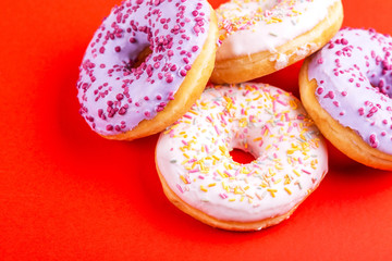 Delicious berry and vanilla donuts on bright red background