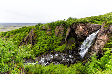 Hundafoss waterfall high angle aerial view in Skaftafell, Iceland with water falling cliff in green summer in rocky landscape
