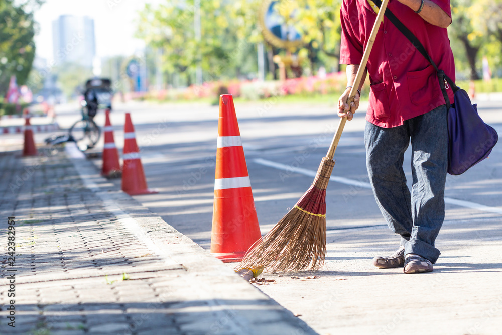 Wall mural man cleaning garbage on the road