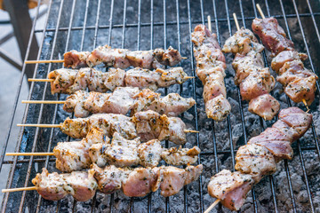 Roasting souvlaki meat sticks on hot charcoal fire grill. Pork, chicken Greek street food  grilled meat. 