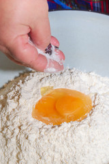 Salt is added to the dough for dumplings in a bowl on the egg