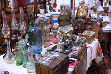 Large glass vases, kerosene lamps and other vintage items on the flea market