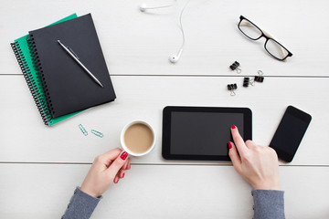  Female hands working on digital tablet. Office desktop on white background.
